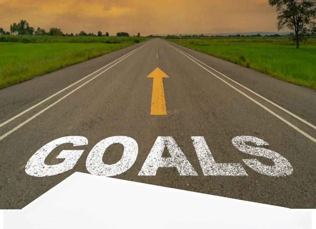 Road with an arrow and the word 'GOALS' painted on it, symbolizing direction and ambition.