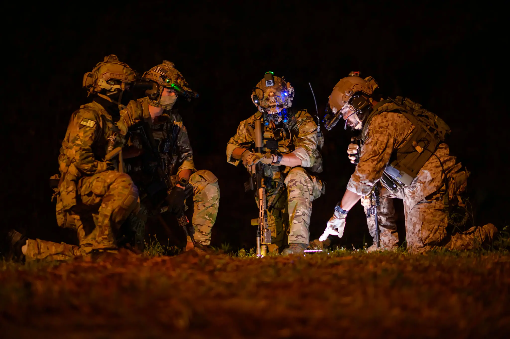 Soldiers in tactical gear engaged in a night operation.