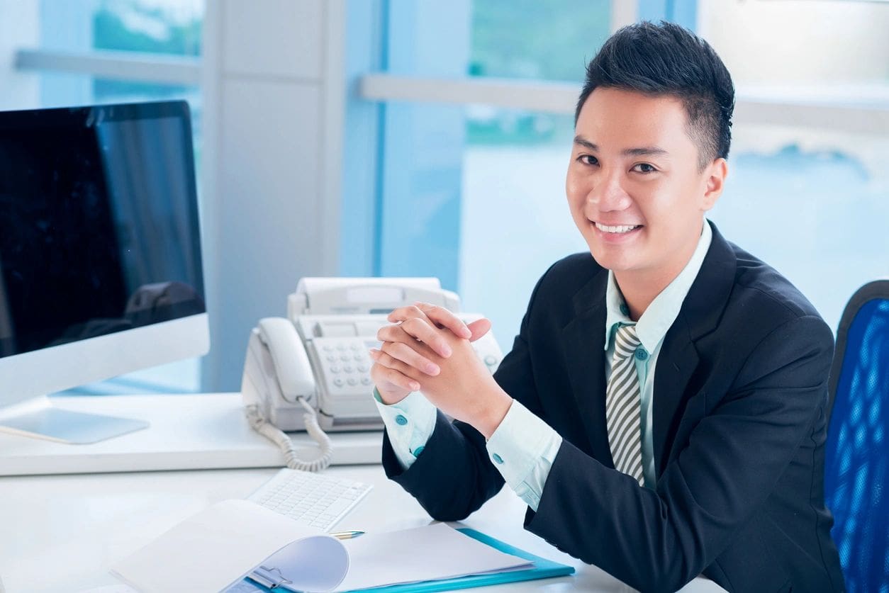 Smiling professional man at office desk.