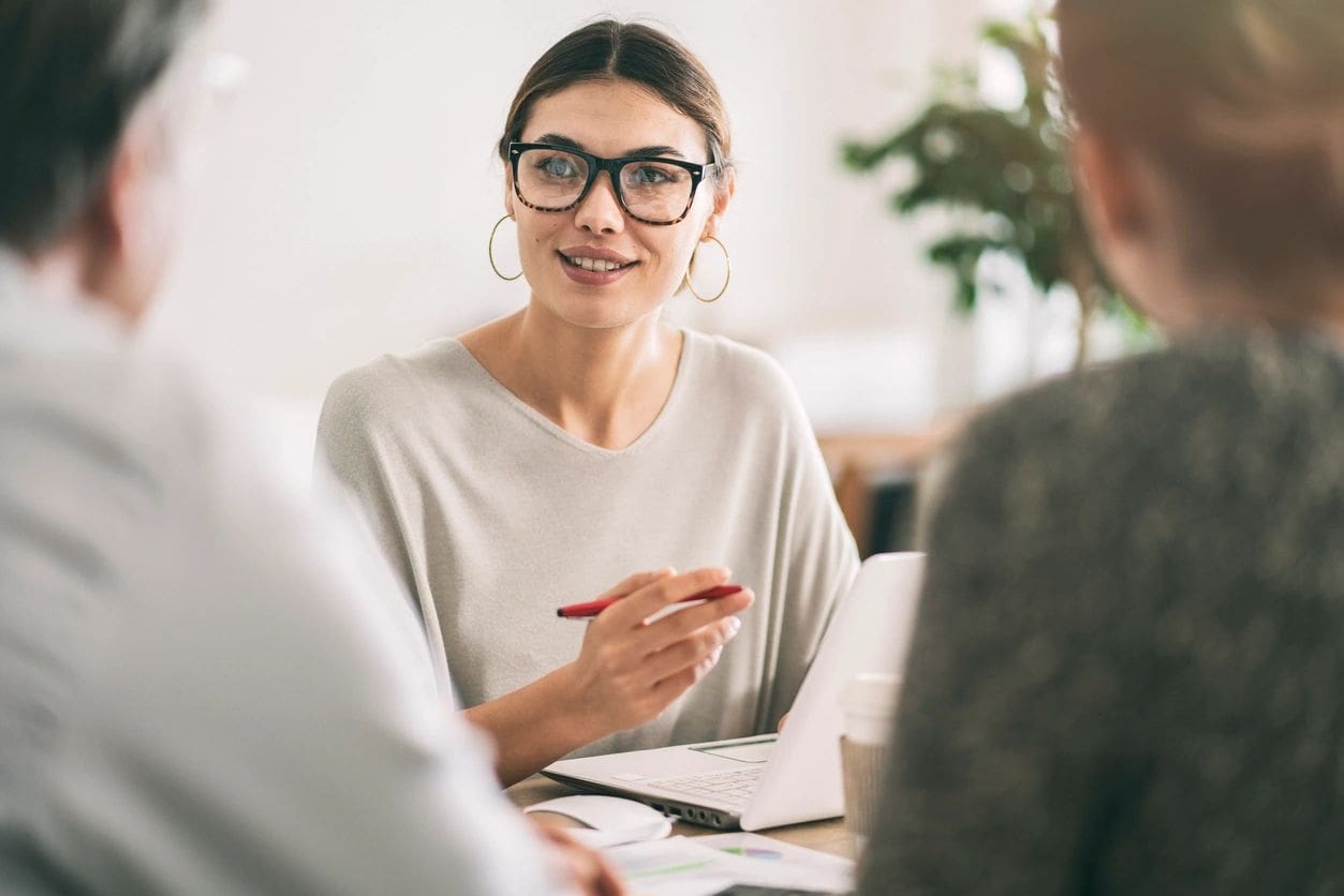 Woman in meeting holding a pen.