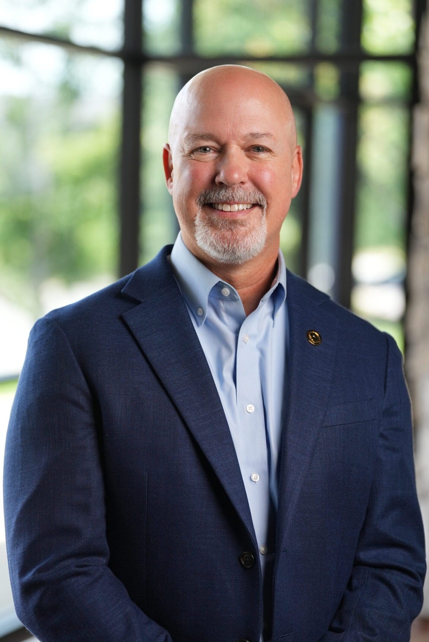 Smiling man in a blue suit jacket and light blue shirt.