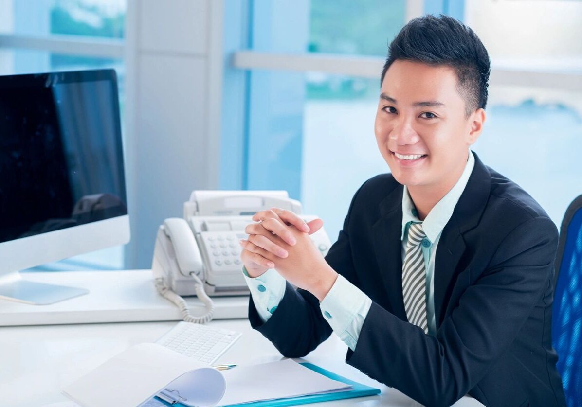 Smiling professional man at office desk.