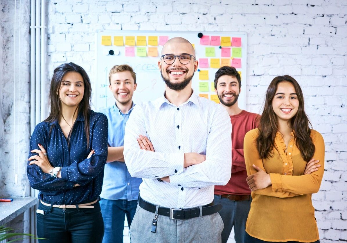 Group of five smiling office colleagues.