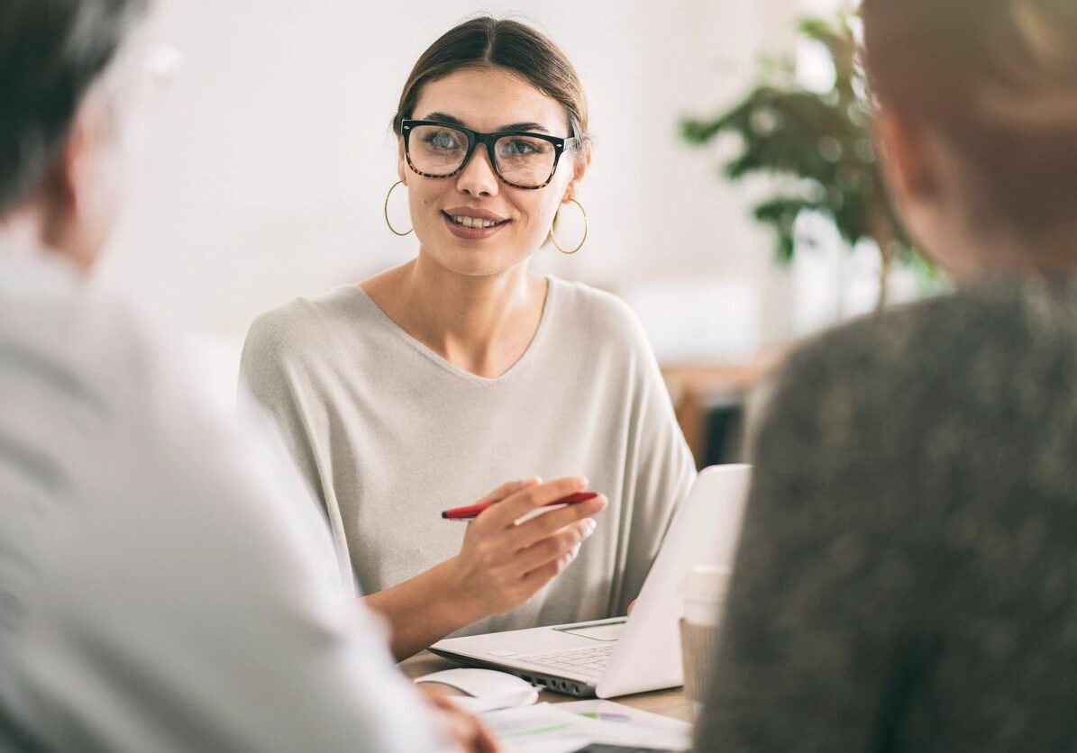 Woman in meeting holding a pen.