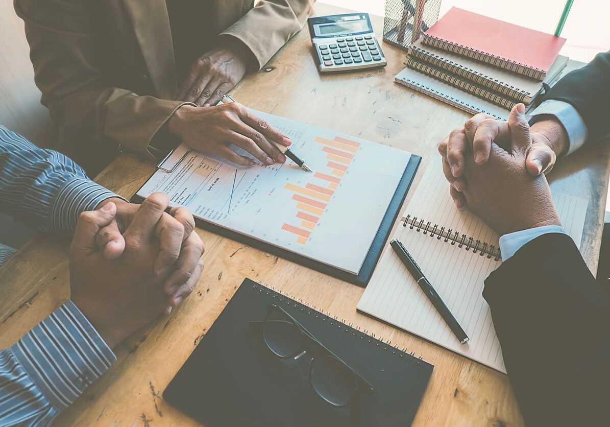 Business meeting with charts and notebooks.